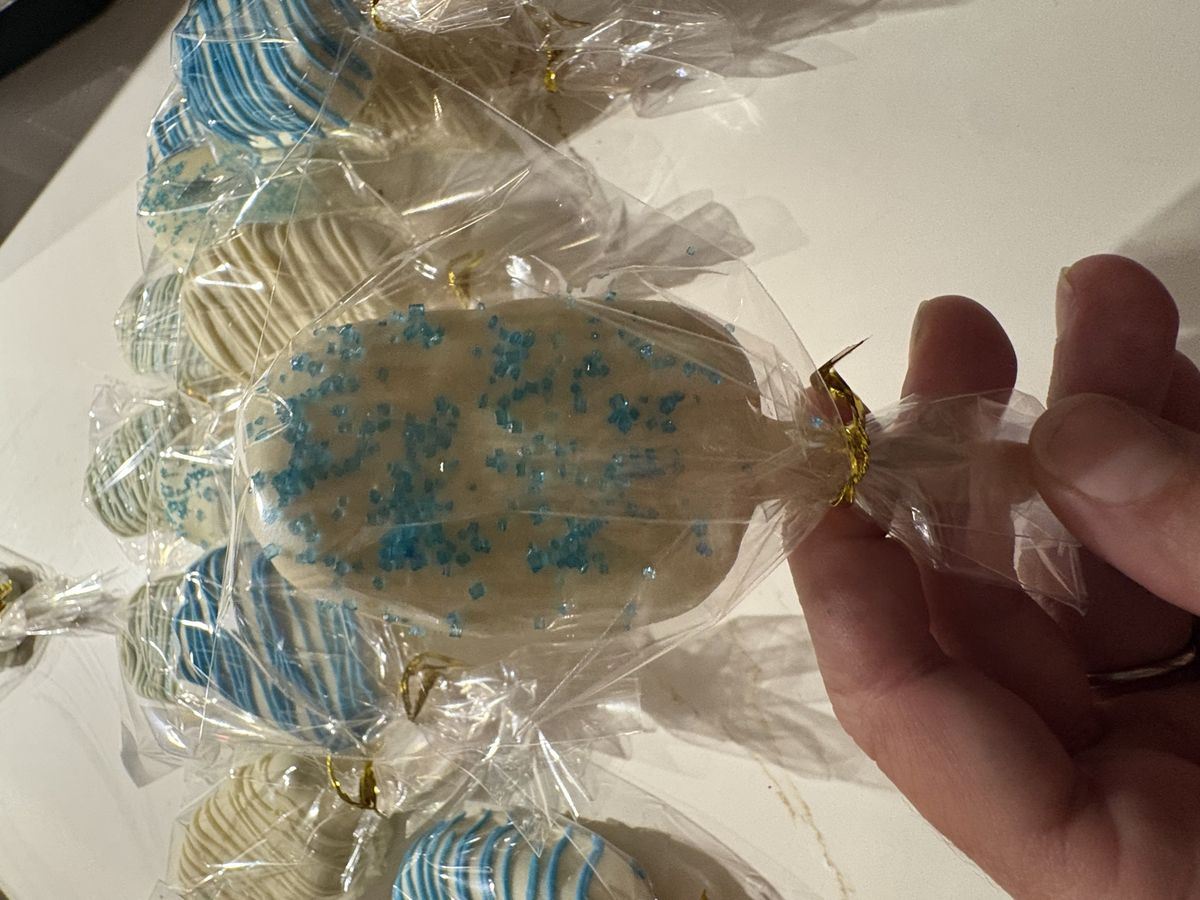 A wrapped white cake pop with blue sugar crystals